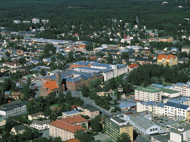 I mitten ses Jakobstads kyrka, t.h. lyceibyggnaden, ritad av Bertel Jung. Bakom tobaksfabriken breder Norrmalm ut sig. Hannu Vallas 1998