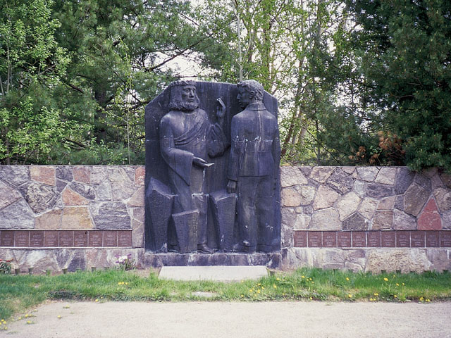 Simpeleen sankarihauta-alueen kiviseinässä on  sankarivainajien nimilaatat sekä kuvanveistäjä Eila Hiltusen pronssireliefi. Marja Terttu Knapas 